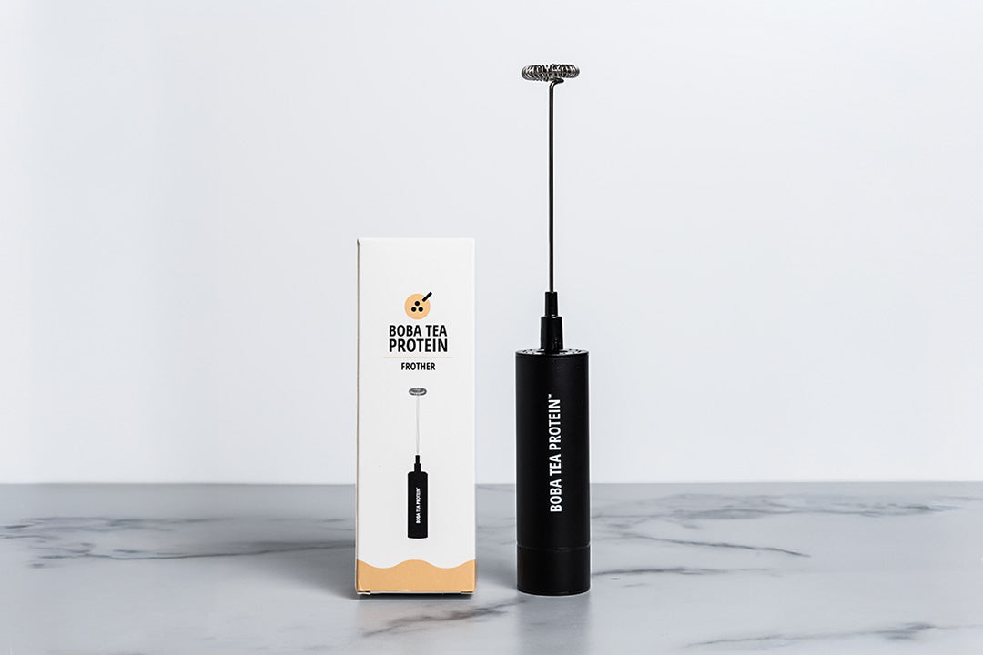 Black handheld milk frother with Boba Tea Protein branding on a white background