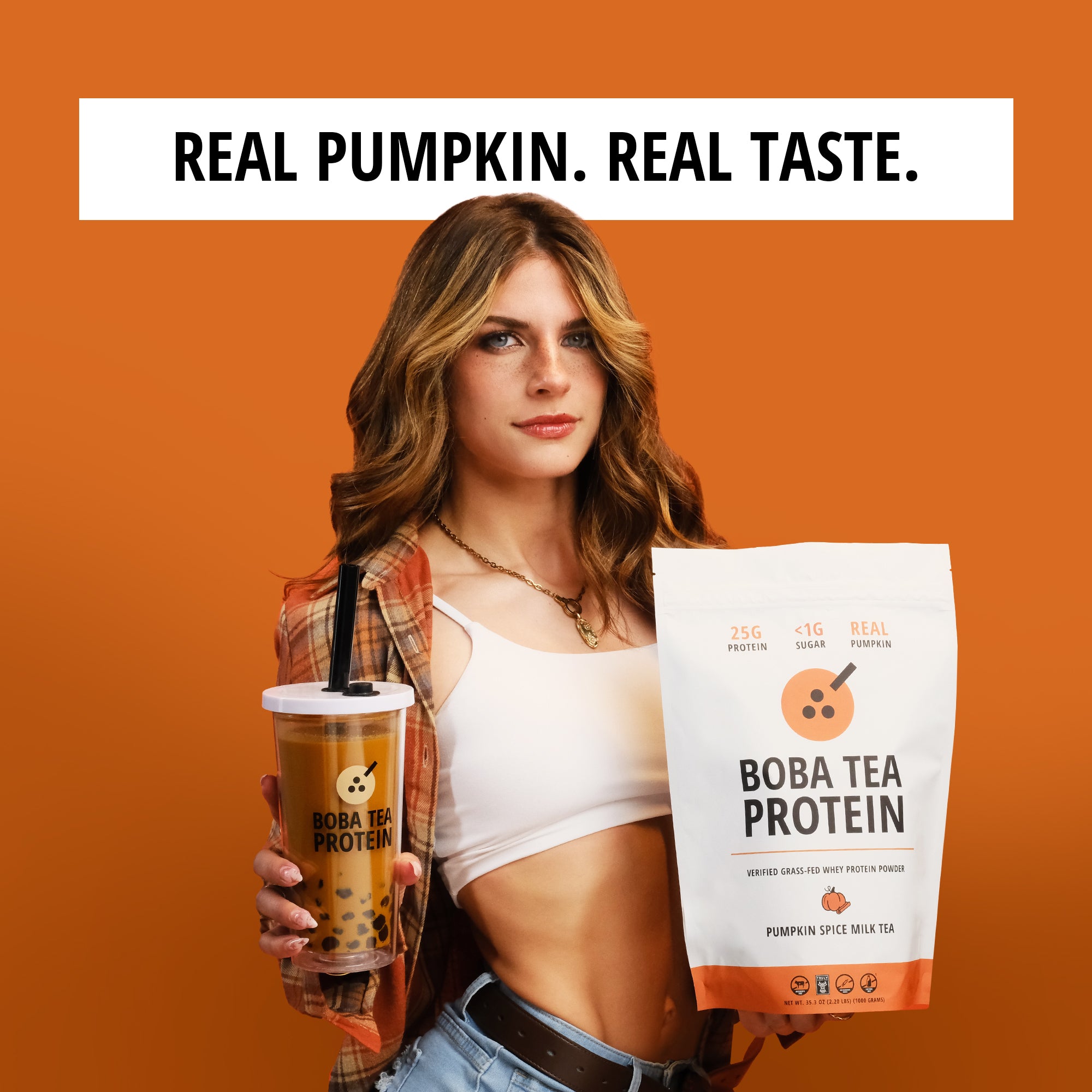 Woman holding a Boba Tea Protein package and a pumpkin spice drink against an orange background