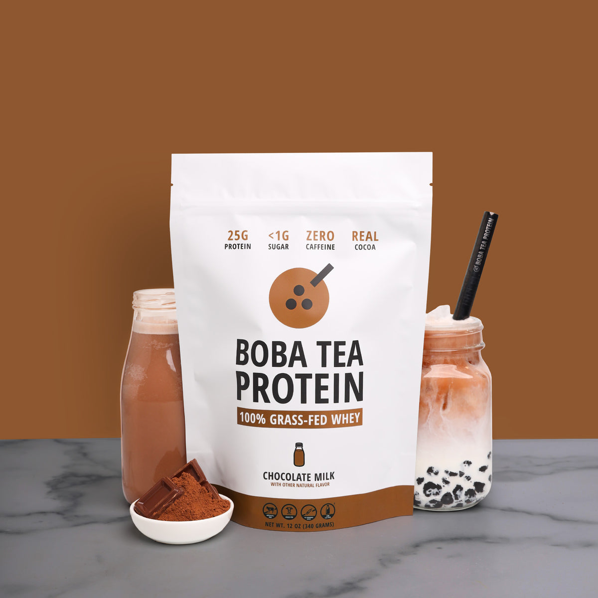 A 10-serving stand-up pouch of Boba Tea Protein Chocolate Milk whey powder stands on a gray marble surface against a solid brown background. The white and brown packaging features a milk bottle graphic and text indicating 25g protein, <1g sugar, zero caffeine, and real cocoa.