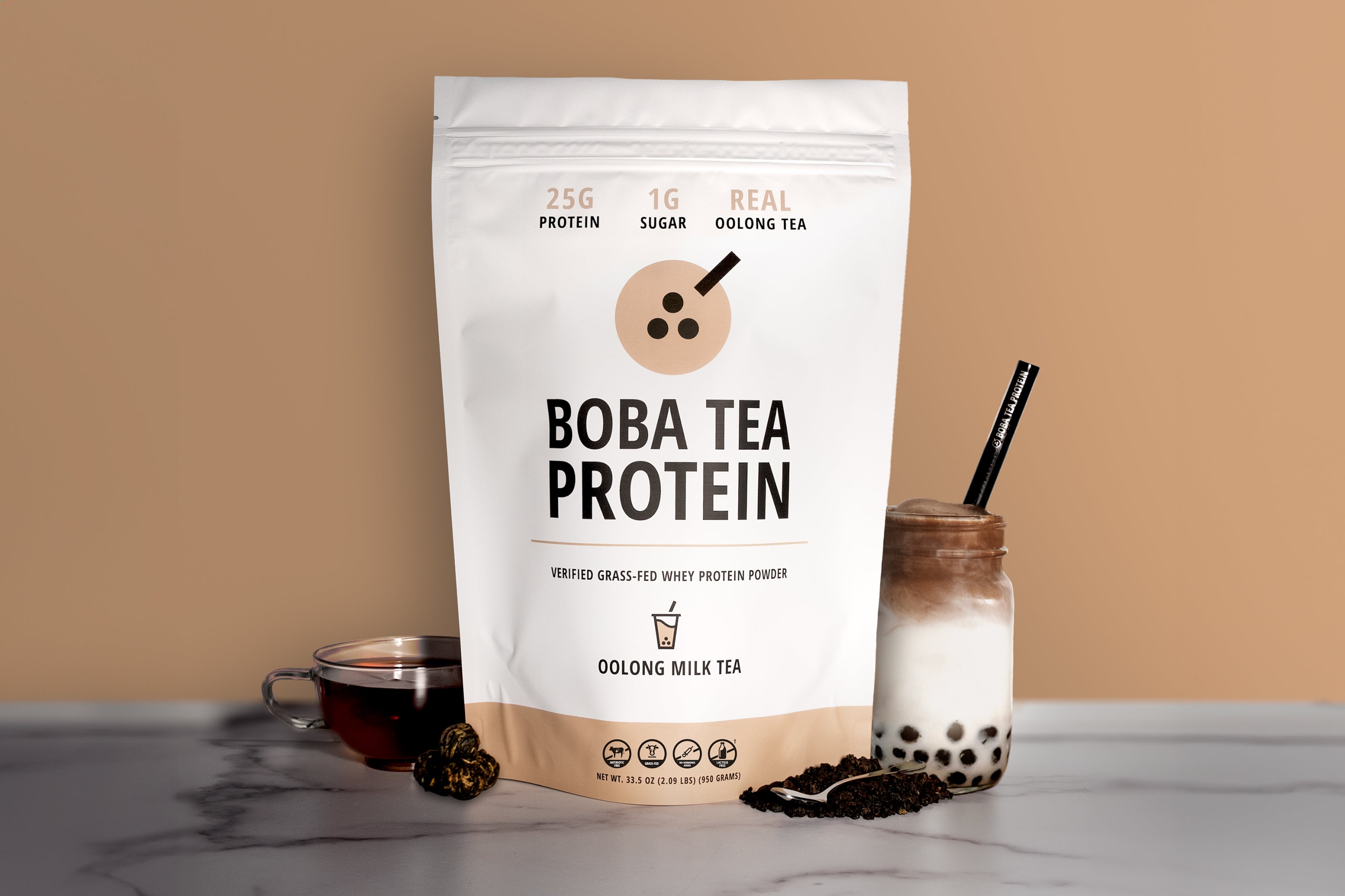 Bag of Boba Tea Protein with a glass of milk tea and ingredients on a beige background