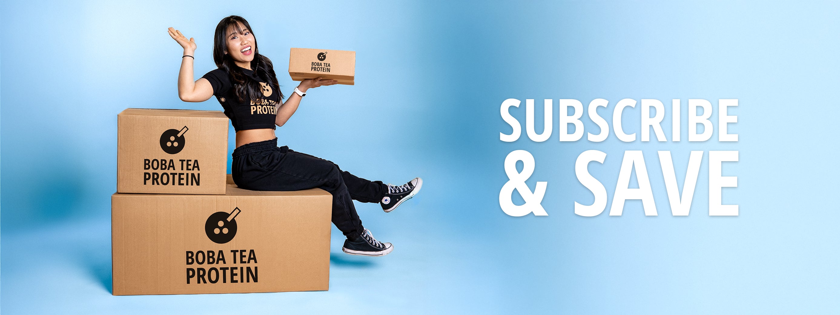 Person sitting on boxes with Boba Tea Protein packaging, promoting 'Subscribe & Save' offer.