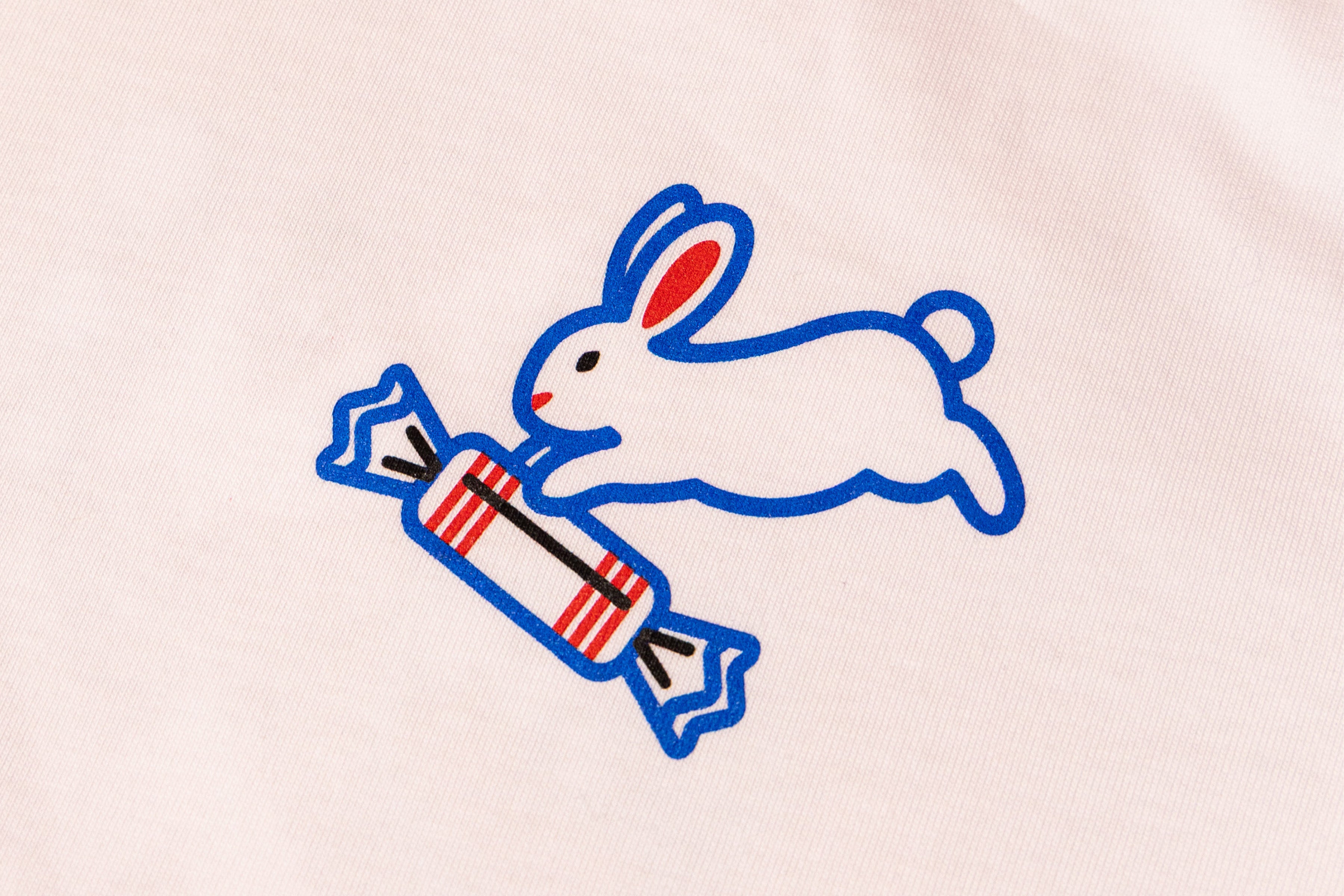 Logo of a blue rabbit holding a red and white striped candy on a white t-shirt
