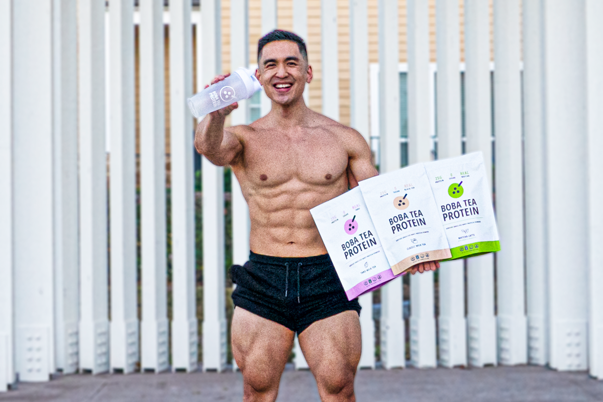 Fit man smiling, holding a shaker bottle and three Boba Tea Protein bags: Taro, Classic, and Matcha flavors.