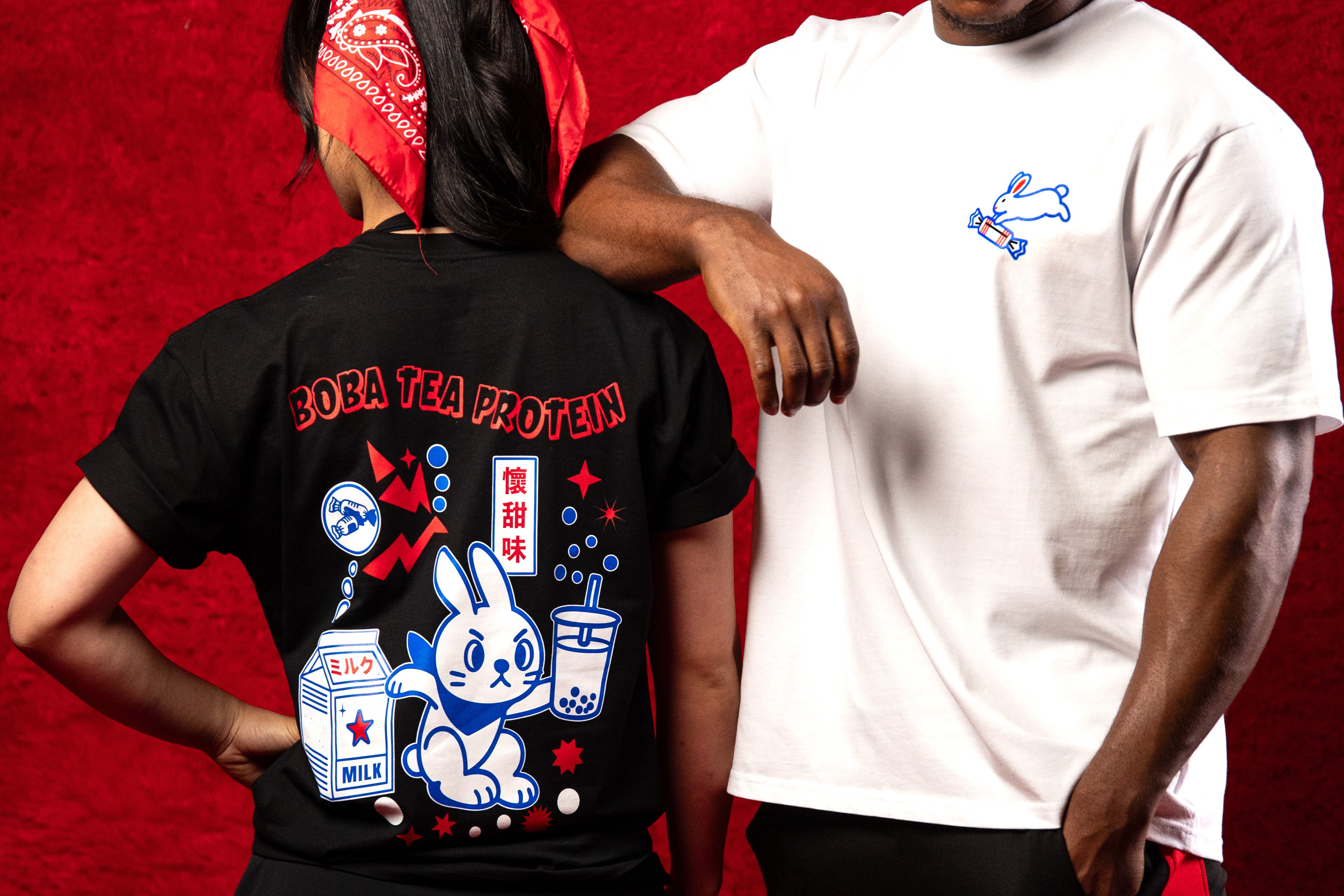 Two people wearing t-shirts with unique designs on a red background