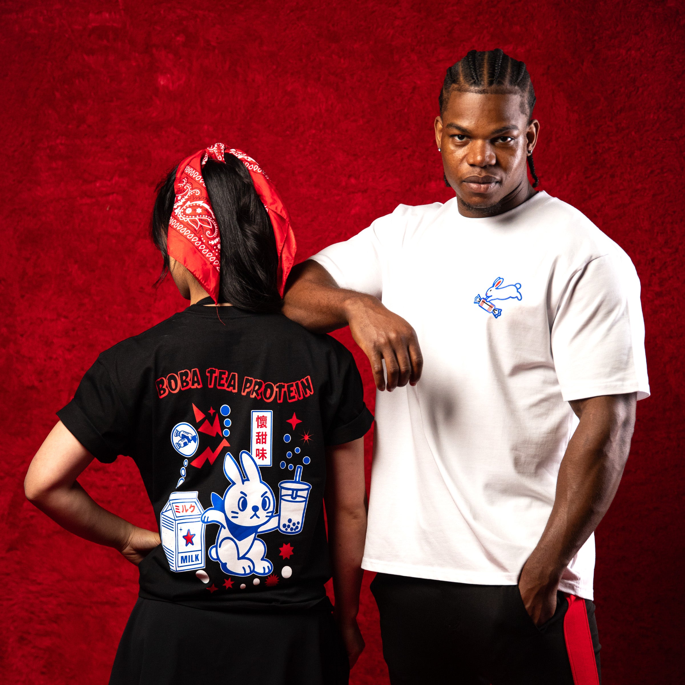 Two people wearing t-shirts with unique designs against a red background