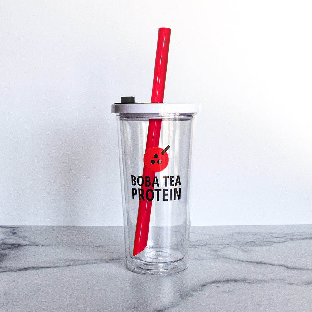 Clear tumbler with red straw and 'Boba Tea Protein' text on a marble surface.
