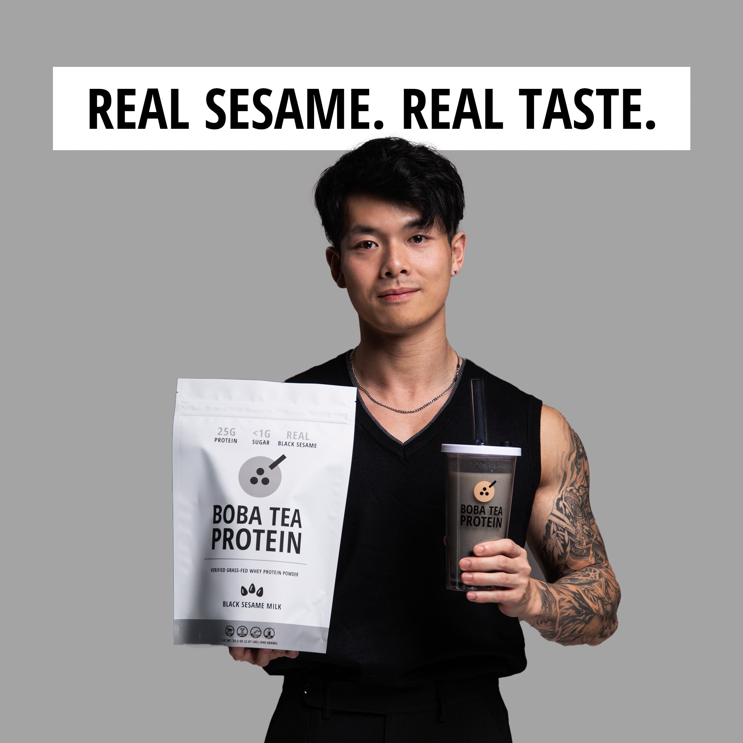 Person holding Boba Tea Protein packaging and a cup against a gray background with 'Real Sesame. Real Taste.' text.