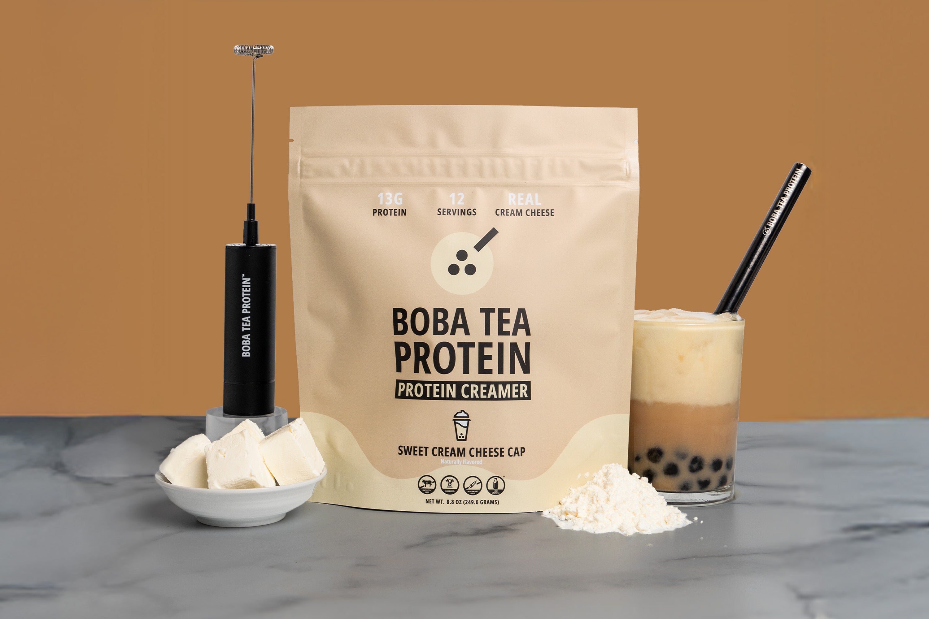Boba Tea Protein package with a glass of bubble tea and protein creamer on a marble surface.