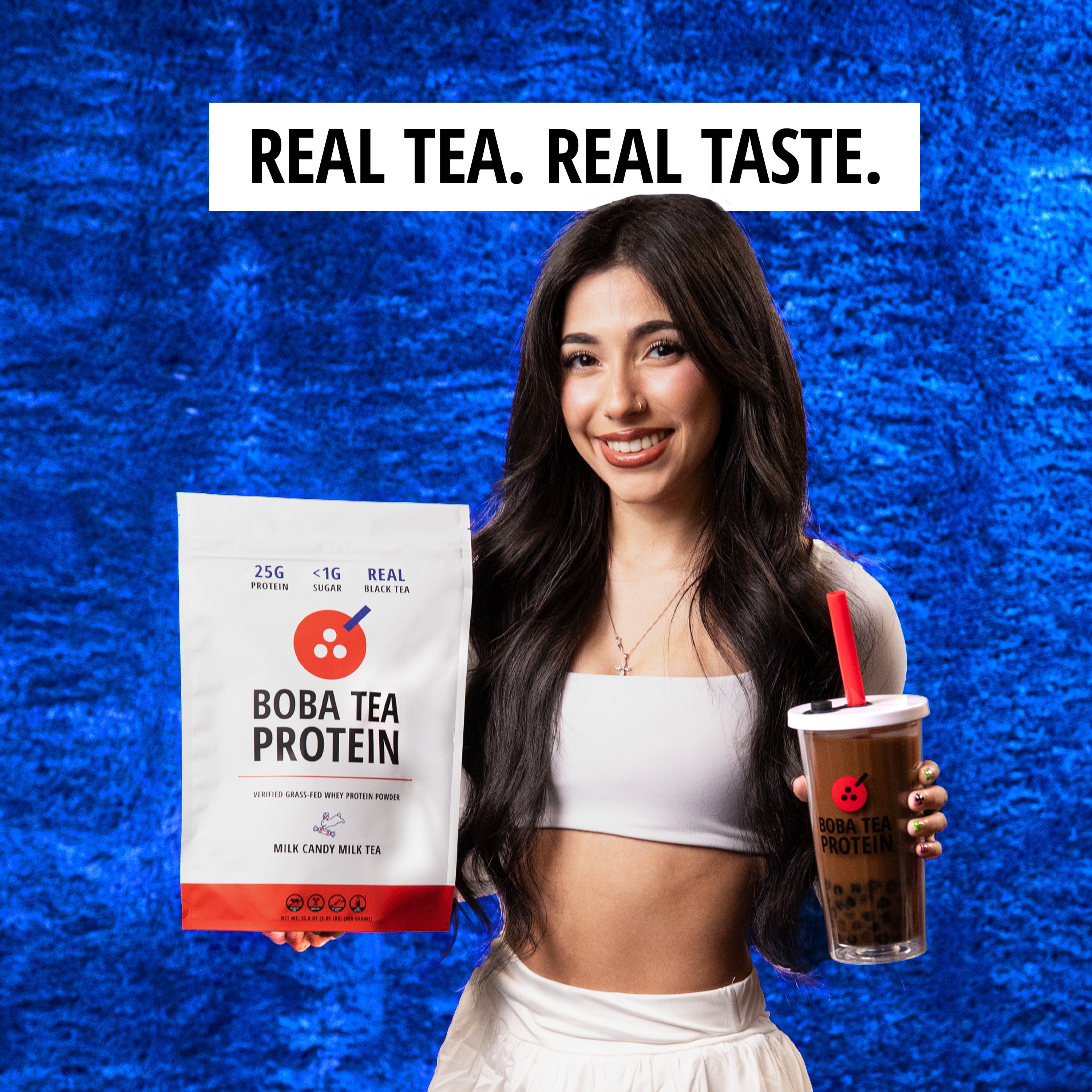 Woman holding Boba Tea Protein package and a cup against a blue textured background with 'Real Tea. Real Taste.' text.
