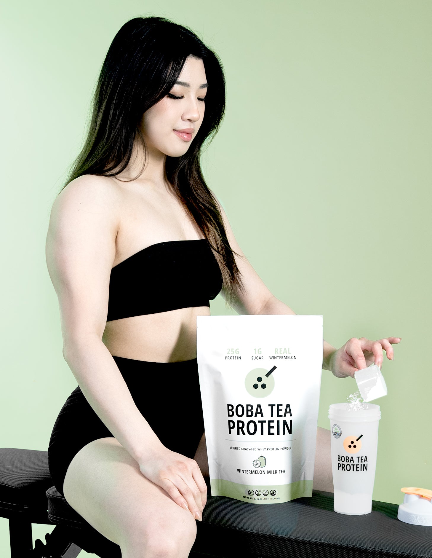 Woman with Boba Tea Protein whey protein packaging against a green background